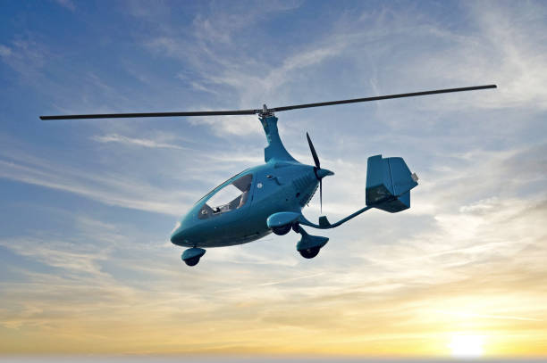 Blue gyroplane in flight at sunrise