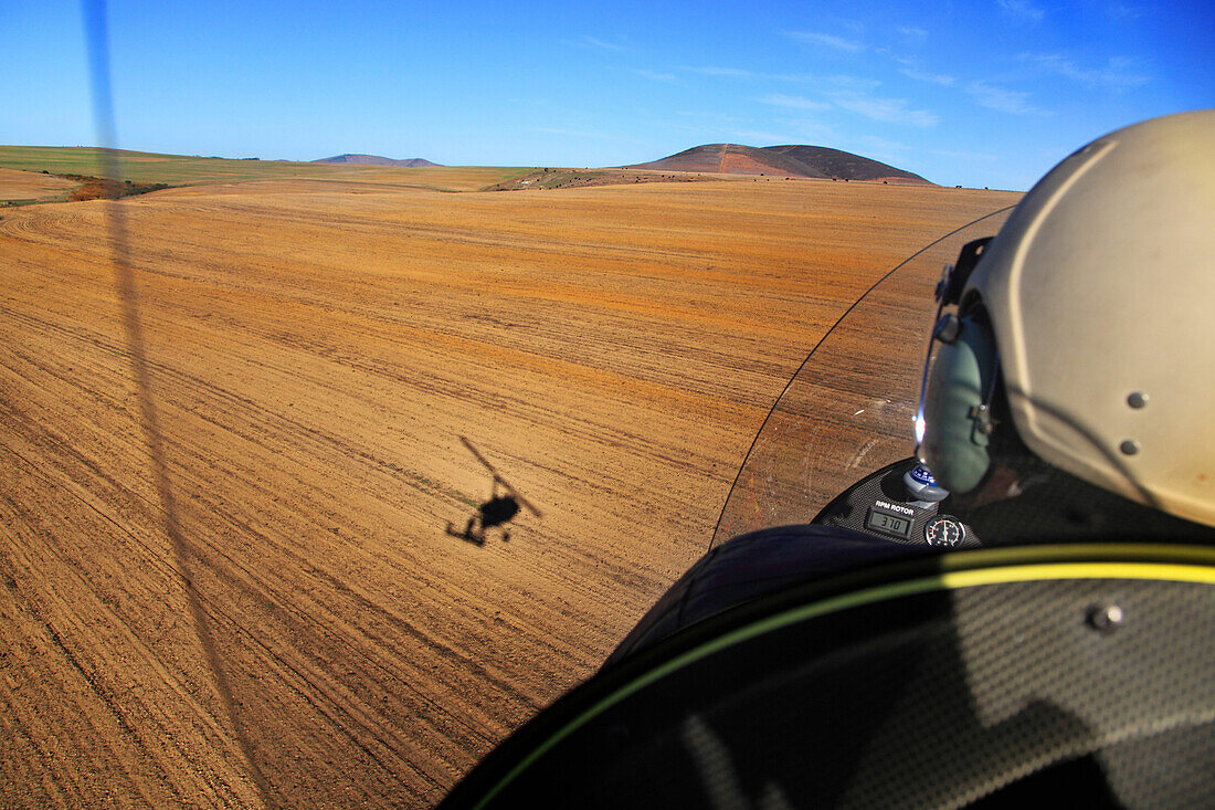 Ship at 800 ft over Swartberg pass — folded rock layers below, long shadow.
